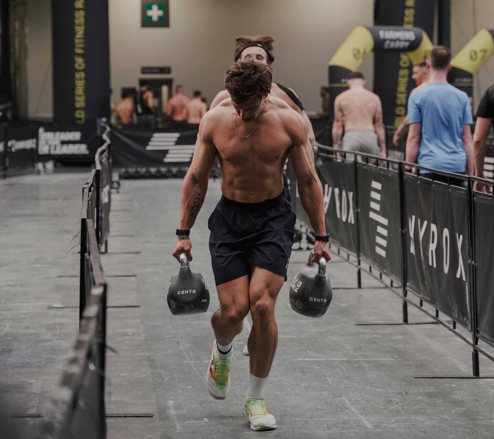 Coach is posing shirtless in a gym.